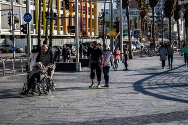 Tel Aviv, İsrail - 13 Şubat 2022 Tel Aviv Güvertesi 'nde yürüyen kimliği belirsiz insanlar, İbranice' de Tayelet olarak bilinir, İsrail 'in Tel Aviv kentindeki Akdeniz kıyısı boyunca uzanır.