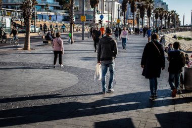 Tel Aviv, İsrail - 13 Şubat 2022 Tel Aviv Güvertesi 'nde yürüyen kimliği belirsiz insanlar, İbranice' de Tayelet olarak bilinir, İsrail 'in Tel Aviv kentindeki Akdeniz kıyısı boyunca uzanır.