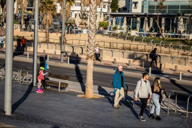 Tel Aviv, İsrail - 13 Şubat 2022 Tel Aviv Güvertesi 'nde yürüyen kimliği belirsiz insanlar, İbranice' de Tayelet olarak bilinir, İsrail 'in Tel Aviv kentindeki Akdeniz kıyısı boyunca uzanır.