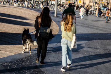 Tel Aviv, İsrail - 13 Şubat 2022 Tel Aviv Güvertesi 'nde yürüyen kimliği belirsiz insanlar, İbranice' de Tayelet olarak bilinir, İsrail 'in Tel Aviv kentindeki Akdeniz kıyısı boyunca uzanır.