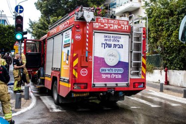 Tel Aviv, İsrail - 15 Mart 2022 İtfaiye aracı Tel Aviv sokaklarına park etmiş, itfaiyeciler şehir merkezindeki bir binanın girişindeki yangını söndürmek için müdahale etmişler.