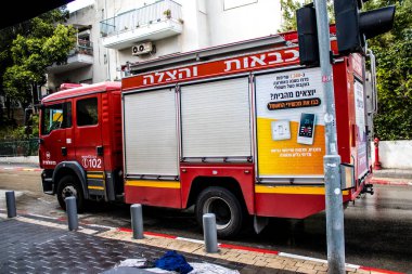 Tel Aviv, İsrail - 15 Mart 2022 İtfaiye aracı Tel Aviv sokaklarına park etmiş, itfaiyeciler şehir merkezindeki bir binanın girişindeki yangını söndürmek için müdahale etmişler.
