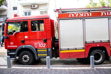 Tel Aviv, İsrail - 15 Mart 2022 İtfaiye aracı Tel Aviv sokaklarına park etmiş, itfaiyeciler şehir merkezindeki bir binanın girişindeki yangını söndürmek için müdahale etmişler.