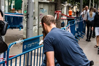 Tel Aviv, İsrail - 8 Nisan 2022 Dizengoff Caddesi 'ndeki Ilka Bar' a düzenlenen terörist saldırının ardından insanlar saldırının gerçekleştiği yere mum ve çiçek bırakmak için geliyorlar.
