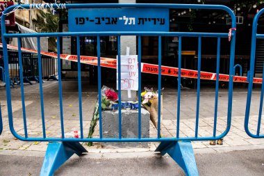 Tel Aviv, İsrail - 8 Nisan 2022 Dizengoff Caddesi 'ndeki Ilka Bar' a düzenlenen terörist saldırının ardından insanlar saldırının gerçekleştiği yere mum ve çiçek bırakmak için geliyorlar.