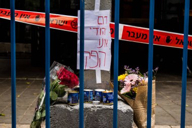 Tel Aviv, İsrail - 8 Nisan 2022 Dizengoff Caddesi 'ndeki Ilka Bar' a düzenlenen terörist saldırının ardından insanlar saldırının gerçekleştiği yere mum ve çiçek bırakmak için geliyorlar.