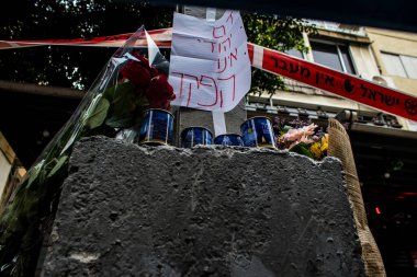 Tel Aviv, İsrail - 8 Nisan 2022 Dizengoff Caddesi 'ndeki Ilka Bar' a düzenlenen terörist saldırının ardından insanlar saldırının gerçekleştiği yere mum ve çiçek bırakmak için geliyorlar.