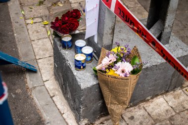 Tel Aviv, İsrail - 8 Nisan 2022 Dizengoff Caddesi 'ndeki Ilka Bar' a düzenlenen terörist saldırının ardından insanlar saldırının gerçekleştiği yere mum ve çiçek bırakmak için geliyorlar.