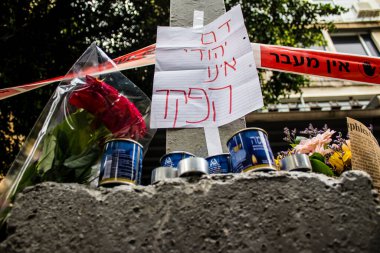 Tel Aviv, İsrail - 8 Nisan 2022 Dizengoff Caddesi 'ndeki Ilka Bar' a düzenlenen terörist saldırının ardından insanlar saldırının gerçekleştiği yere mum ve çiçek bırakmak için geliyorlar.