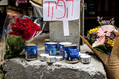 Tel Aviv, İsrail - 8 Nisan 2022 Dizengoff Caddesi 'ndeki Ilka Bar' a düzenlenen terörist saldırının ardından insanlar saldırının gerçekleştiği yere mum ve çiçek bırakmak için geliyorlar.