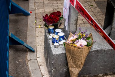 Tel Aviv, İsrail - 8 Nisan 2022 Dizengoff Caddesi 'ndeki Ilka Bar' a düzenlenen terörist saldırının ardından insanlar saldırının gerçekleştiği yere mum ve çiçek bırakmak için geliyorlar.
