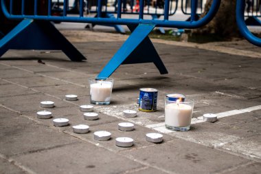 Tel Aviv, İsrail - 8 Nisan 2022 Dizengoff Caddesi 'ndeki Ilka Bar' a düzenlenen terörist saldırının ardından insanlar saldırının gerçekleştiği yere mum ve çiçek bırakmak için geliyorlar.