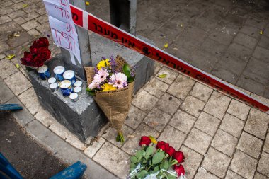 Tel Aviv, İsrail - 8 Nisan 2022 Dizengoff Caddesi 'ndeki Ilka Bar' a düzenlenen terörist saldırının ardından insanlar saldırının gerçekleştiği yere mum ve çiçek bırakmak için geliyorlar.