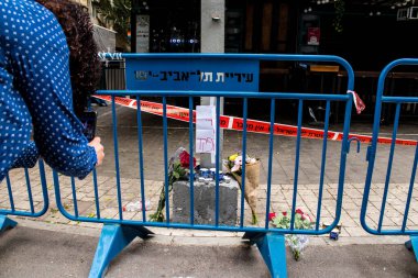Tel Aviv, İsrail - 8 Nisan 2022 Dizengoff Caddesi 'ndeki Ilka Bar' a düzenlenen terörist saldırının ardından insanlar saldırının gerçekleştiği yere mum ve çiçek bırakmak için geliyorlar.