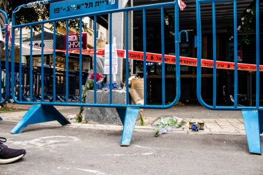 Tel Aviv, İsrail - 8 Nisan 2022 Dizengoff Caddesi 'ndeki Ilka Bar' a düzenlenen terörist saldırının ardından insanlar saldırının gerçekleştiği yere mum ve çiçek bırakmak için geliyorlar.