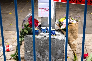 Tel Aviv, İsrail - 8 Nisan 2022 Dizengoff Caddesi 'ndeki Ilka Bar' a düzenlenen terörist saldırının ardından insanlar saldırının gerçekleştiği yere mum ve çiçek bırakmak için geliyorlar.