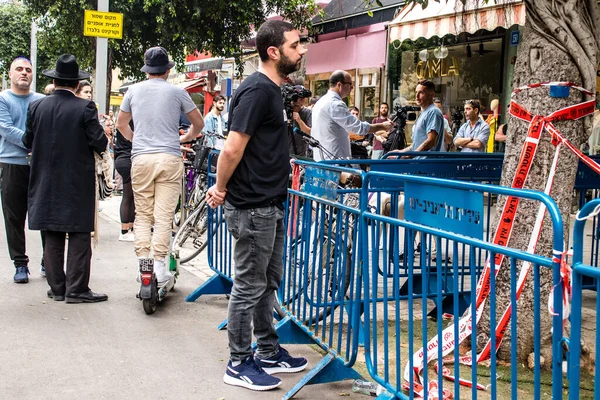 Tel Aviv, İsrail - 8 Nisan 2022 Dizengoff Caddesi 'ndeki Ilka Bar' a düzenlenen terörist saldırının ardından insanlar saldırının gerçekleştiği yere mum ve çiçek bırakmak için geliyorlar.