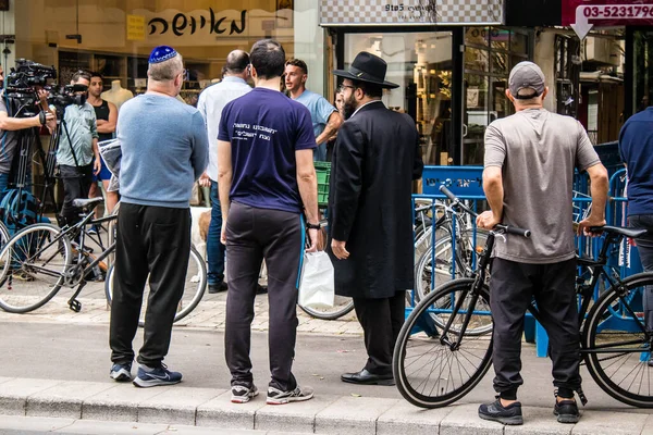 Tel Aviv, İsrail - 8 Nisan 2022 Dizengoff Caddesi 'ndeki Ilka Bar' a düzenlenen terörist saldırının ardından insanlar saldırının gerçekleştiği yere mum ve çiçek bırakmak için geliyorlar.