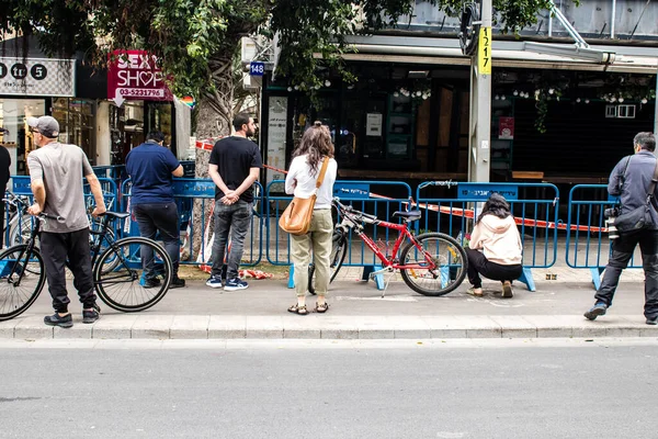 Tel Aviv, İsrail - 8 Nisan 2022 Dizengoff Caddesi 'ndeki Ilka Bar' a düzenlenen terörist saldırının ardından insanlar saldırının gerçekleştiği yere mum ve çiçek bırakmak için geliyorlar.