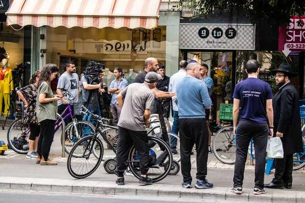Tel Aviv, İsrail - 8 Nisan 2022 Dizengoff Caddesi 'ndeki Ilka Bar' a düzenlenen terörist saldırının ardından insanlar saldırının gerçekleştiği yere mum ve çiçek bırakmak için geliyorlar.