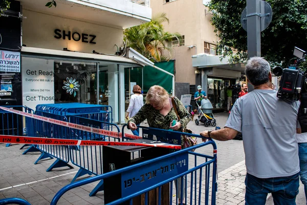 Tel Aviv, İsrail - 8 Nisan 2022 Dizengoff Caddesi 'ndeki Ilka Bar' a düzenlenen terörist saldırının ardından insanlar saldırının gerçekleştiği yere mum ve çiçek bırakmak için geliyorlar.