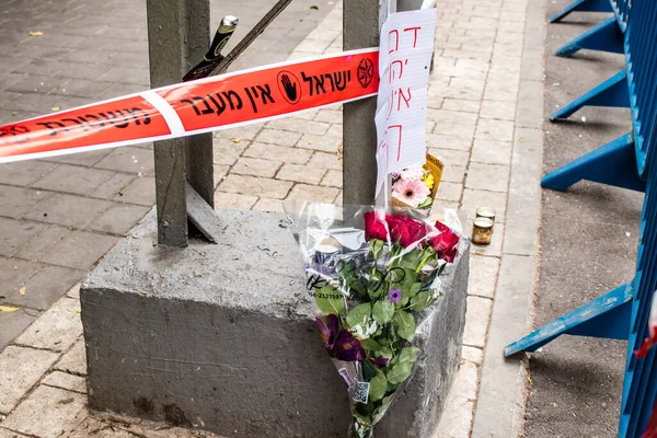 Tel Aviv, İsrail - 8 Nisan 2022 Dizengoff Caddesi 'ndeki Ilka Bar' a düzenlenen terörist saldırının ardından insanlar saldırının gerçekleştiği yere mum ve çiçek bırakmak için geliyorlar.