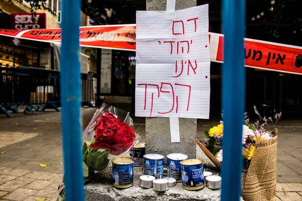 Tel Aviv, İsrail - 8 Nisan 2022 Dizengoff Caddesi 'ndeki Ilka Bar' a düzenlenen terörist saldırının ardından insanlar saldırının gerçekleştiği yere mum ve çiçek bırakmak için geliyorlar.