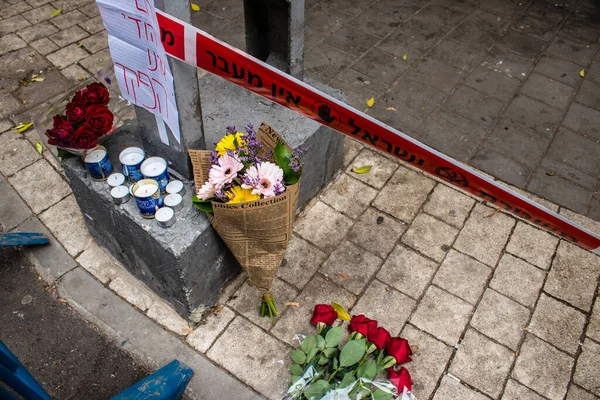 Tel Aviv, İsrail - 8 Nisan 2022 Dizengoff Caddesi 'ndeki Ilka Bar' a düzenlenen terörist saldırının ardından insanlar saldırının gerçekleştiği yere mum ve çiçek bırakmak için geliyorlar.
