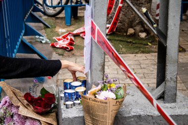 Tel Aviv, İsrail - 8 Nisan 2022 Dizengoff Caddesi 'ndeki Ilka Bar' a düzenlenen terörist saldırının ardından insanlar saldırının gerçekleştiği yere mum ve çiçek bırakmak için geliyorlar.