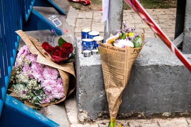 Tel Aviv, İsrail - 8 Nisan 2022 Dizengoff Caddesi 'ndeki Ilka Bar' a düzenlenen terörist saldırının ardından insanlar saldırının gerçekleştiği yere mum ve çiçek bırakmak için geliyorlar.