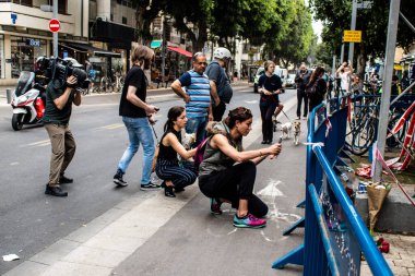 Tel Aviv, İsrail - 8 Nisan 2022 Dizengoff Caddesi 'ndeki Ilka Bar' a düzenlenen terörist saldırının ardından insanlar saldırının gerçekleştiği yere mum ve çiçek bırakmak için geliyorlar.