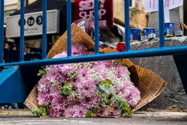 Tel Aviv, İsrail - 8 Nisan 2022 Dizengoff Caddesi 'ndeki Ilka Bar' a düzenlenen terörist saldırının ardından insanlar saldırının gerçekleştiği yere mum ve çiçek bırakmak için geliyorlar.
