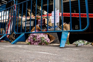 Tel Aviv, İsrail - 8 Nisan 2022 Dizengoff Caddesi 'ndeki Ilka Bar' a düzenlenen terörist saldırının ardından insanlar saldırının gerçekleştiği yere mum ve çiçek bırakmak için geliyorlar.