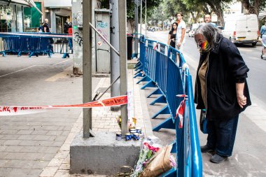 Tel Aviv, İsrail - 8 Nisan 2022 Dizengoff Caddesi 'ndeki Ilka Bar' a düzenlenen terörist saldırının ardından insanlar saldırının gerçekleştiği yere mum ve çiçek bırakmak için geliyorlar.