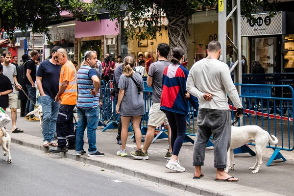 Tel Aviv, İsrail - 8 Nisan 2022 Dizengoff Caddesi 'ndeki Ilka Bar' a düzenlenen terörist saldırının ardından insanlar saldırının gerçekleştiği yere mum ve çiçek bırakmak için geliyorlar.