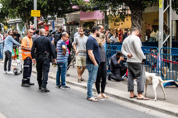 Tel Aviv, İsrail - 8 Nisan 2022 Dizengoff Caddesi 'ndeki Ilka Bar' a düzenlenen terörist saldırının ardından insanlar saldırının gerçekleştiği yere mum ve çiçek bırakmak için geliyorlar.