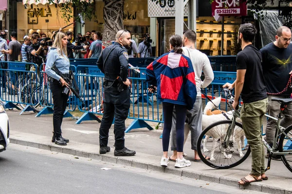 Tel Aviv, İsrail - 8 Nisan 2022 Dizengoff Caddesi 'ndeki Ilka Bar' a düzenlenen terörist saldırının ardından insanlar saldırının gerçekleştiği yere mum ve çiçek bırakmak için geliyorlar.