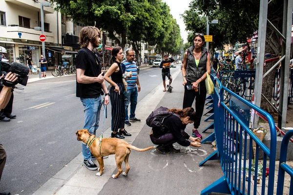 Tel Aviv, İsrail - 8 Nisan 2022 Dizengoff Caddesi 'ndeki Ilka Bar' a düzenlenen terörist saldırının ardından insanlar saldırının gerçekleştiği yere mum ve çiçek bırakmak için geliyorlar.
