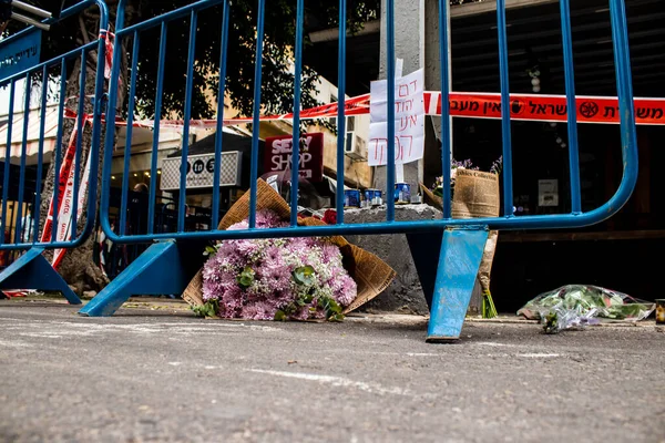 Tel Aviv, İsrail - 8 Nisan 2022 Dizengoff Caddesi 'ndeki Ilka Bar' a düzenlenen terörist saldırının ardından insanlar saldırının gerçekleştiği yere mum ve çiçek bırakmak için geliyorlar.