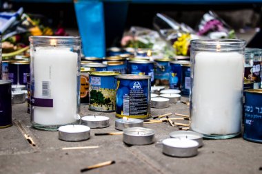 Tel Aviv, İsrail - 8 Nisan 2022 Dizengoff Caddesi 'ndeki Ilka Bar' a düzenlenen terörist saldırının ardından insanlar saldırının gerçekleştiği yere mum ve çiçek bırakmak için geliyorlar.