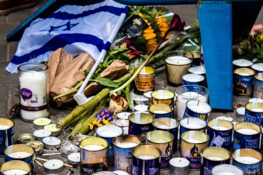 Tel Aviv, İsrail - 8 Nisan 2022 Dizengoff Caddesi 'ndeki Ilka Bar' a düzenlenen terörist saldırının ardından insanlar saldırının gerçekleştiği yere mum ve çiçek bırakmak için geliyorlar.