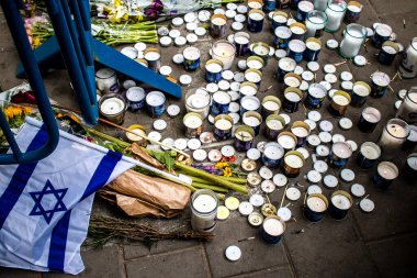 Tel Aviv, İsrail - 8 Nisan 2022 Dizengoff Caddesi 'ndeki Ilka Bar' a düzenlenen terörist saldırının ardından insanlar saldırının gerçekleştiği yere mum ve çiçek bırakmak için geliyorlar.