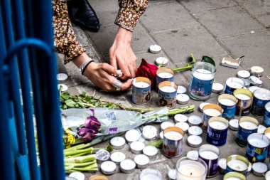 Tel Aviv, İsrail - 8 Nisan 2022 Dizengoff Caddesi 'ndeki Ilka Bar' a düzenlenen terörist saldırının ardından insanlar saldırının gerçekleştiği yere mum ve çiçek bırakmak için geliyorlar.