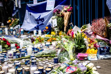 Tel Aviv, İsrail - 8 Nisan 2022 Dizengoff Caddesi 'ndeki Ilka Bar' a düzenlenen terörist saldırının ardından insanlar saldırının gerçekleştiği yere mum ve çiçek bırakmak için geliyorlar.