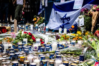 Tel Aviv, İsrail - 8 Nisan 2022 Dizengoff Caddesi 'ndeki Ilka Bar' a düzenlenen terörist saldırının ardından insanlar saldırının gerçekleştiği yere mum ve çiçek bırakmak için geliyorlar.