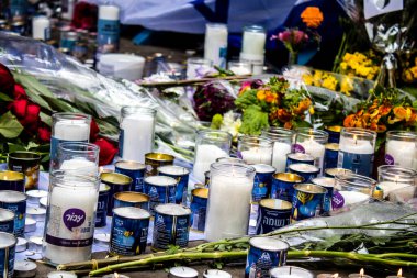 Tel Aviv, İsrail - 8 Nisan 2022 Dizengoff Caddesi 'ndeki Ilka Bar' a düzenlenen terörist saldırının ardından insanlar saldırının gerçekleştiği yere mum ve çiçek bırakmak için geliyorlar.