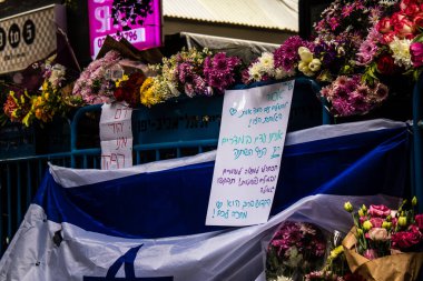 Tel Aviv, İsrail - 8 Nisan 2022 Dizengoff Caddesi 'ndeki Ilka Bar' a düzenlenen terörist saldırının ardından insanlar saldırının gerçekleştiği yere mum ve çiçek bırakmak için geliyorlar.