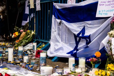 Tel Aviv, İsrail - 8 Nisan 2022 Dizengoff Caddesi 'ndeki Ilka Bar' a düzenlenen terörist saldırının ardından insanlar saldırının gerçekleştiği yere mum ve çiçek bırakmak için geliyorlar.