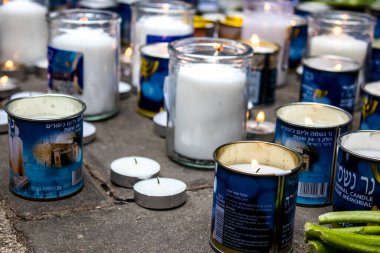Tel Aviv, İsrail - 8 Nisan 2022 Dizengoff Caddesi 'ndeki Ilka Bar' a düzenlenen terörist saldırının ardından insanlar saldırının gerçekleştiği yere mum ve çiçek bırakmak için geliyorlar.