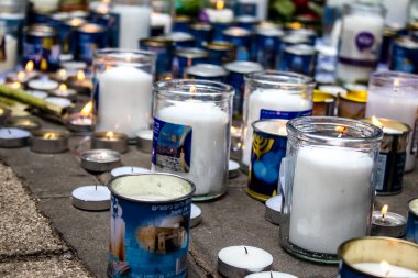 Tel Aviv, İsrail - 8 Nisan 2022 Dizengoff Caddesi 'ndeki Ilka Bar' a düzenlenen terörist saldırının ardından insanlar saldırının gerçekleştiği yere mum ve çiçek bırakmak için geliyorlar.